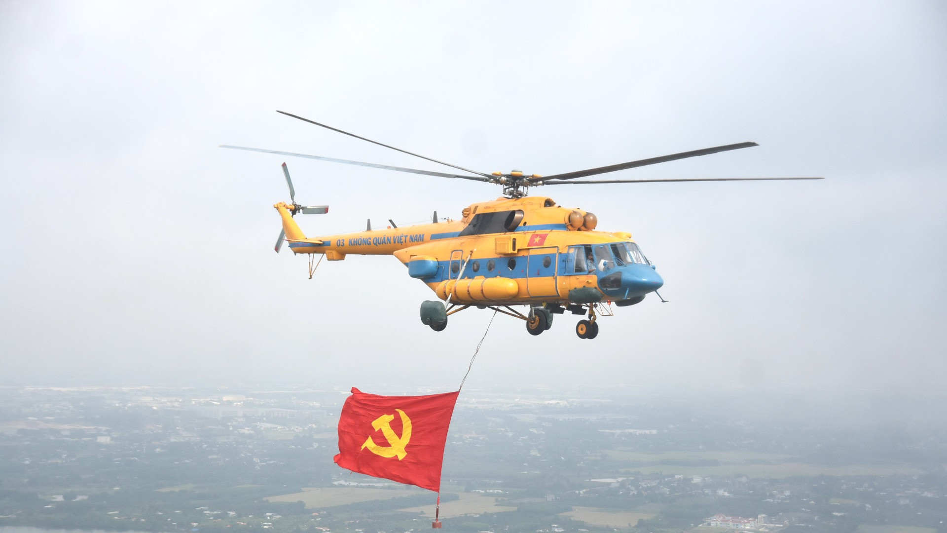 Máy bay trực thăng kéo theo cờ Đảng từ sân bay Biên Hòa hướng đến bầu trời Thành phố Hồ Chí Minh.