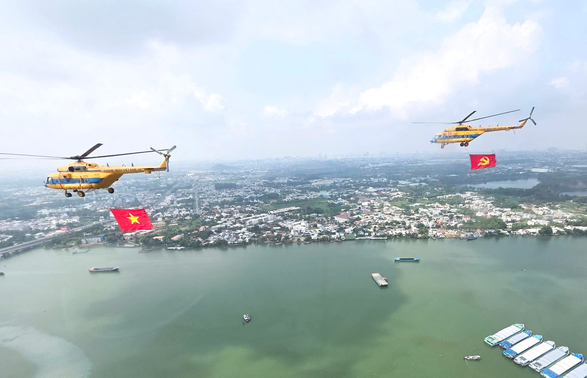 Hai trực thăng luyện tập kéo theo cờ Đảng, cờ Tổ quốc.