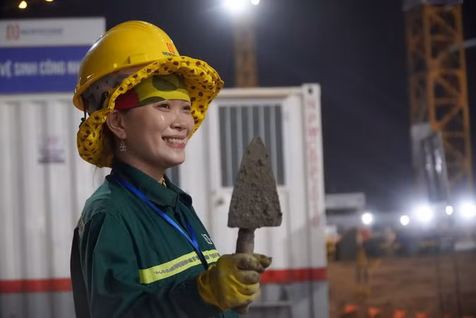 Nụ cười của nữ công nhân làm việc ban đêm trên công trường dự án sân bay Long Thành.