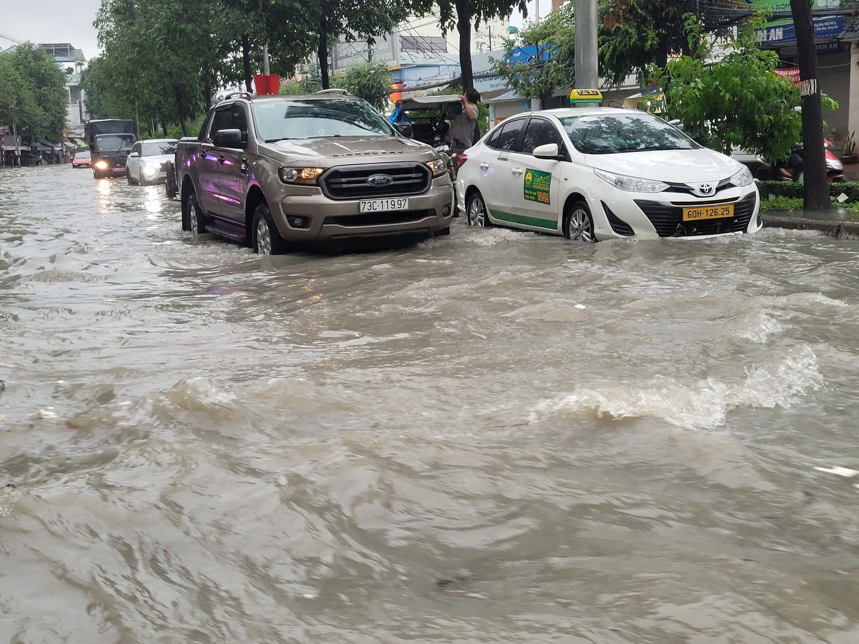 Nhiều ô-tô cố gắng vượt qua dòng nước.