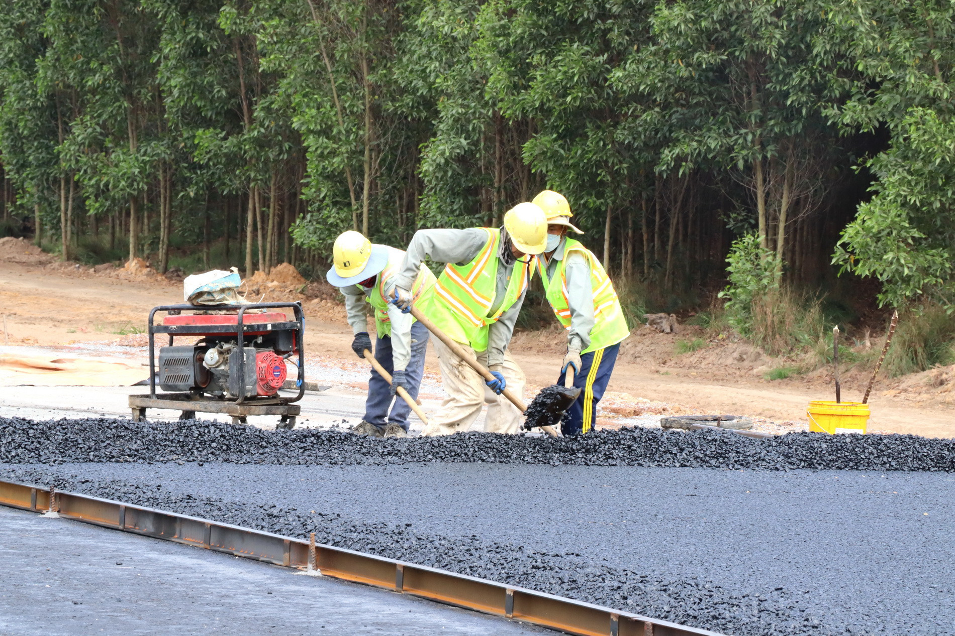 Công nhân thực hiện những thảm bê-tông nhựa đầu tiên trên cao tốc Biên Hòa-Vũng Tàu, đoạn thuộc địa phận xã An Phước, huyện Long Thành, tỉnh Đồng Nai.