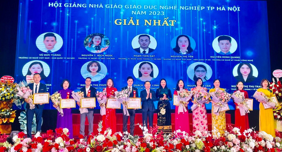 Thứ trưởng Lao động-Thương binh và Xã hội Lê Tấn Dũng và Giám đốc Sở Lao động-Thương binh và Xã hội Hà Nội Bạch Liên Hương tặng hoa và trao giải nhất cho 10 nhà giáo đạt giải tại Hội giảng Nhà giáo giáo dục nghề nghiệp Thủ đô năm 2023. (Ảnh: GDVT)