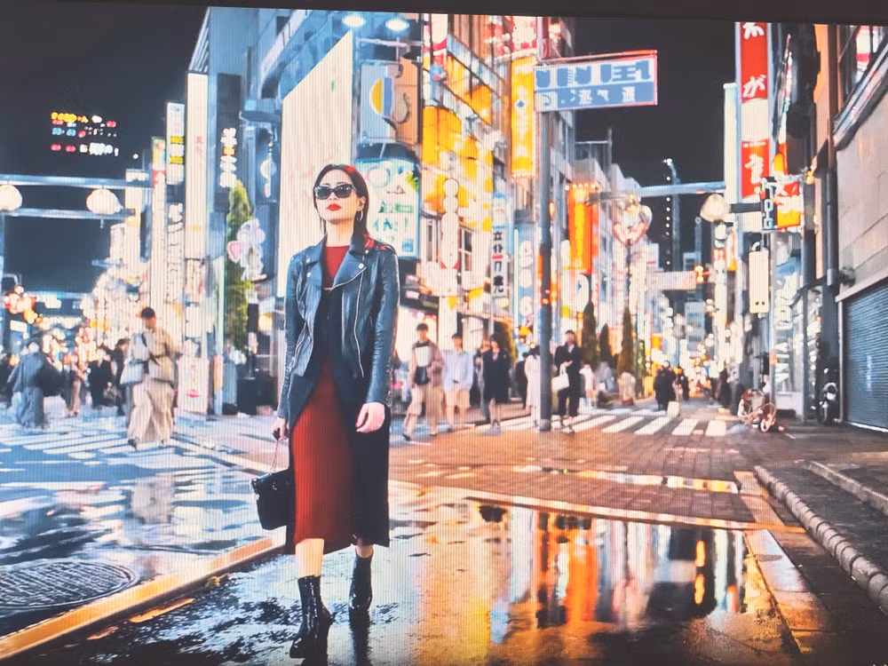 Ảnh chụp từ videoclip được tạo ra từ AI với câu lệnh mô tả một cô gái đang đi trên đường phố Nhật Bản với mái tóc nâu và nước da trắng, đeo kính.