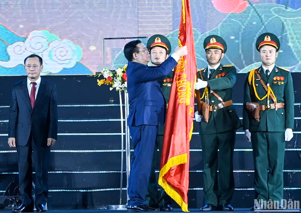 Chủ tịch Quốc hội Vương Đình Huệ gắn Huân chương lên cờ truyền thống.