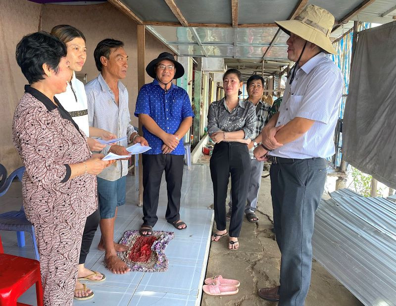 Bí thư Huyện ủy Năm Căn (tỉnh Cà Mau) Dư Minh Hùng (bìa phải) thăm hỏi, động viên các hộ dân có nhà bị sạt lở ở xã Tam Giang. 