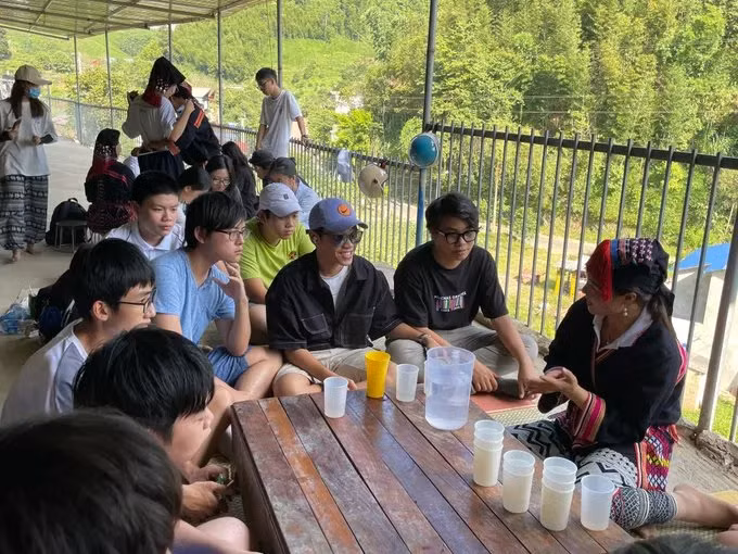 Trải nghiệm làm vải chàm sáp ong cùng người Dao Tiền của Nhật Minh (thứ ba từ phải sang) và các bạn. (Ảnh: NVCC)