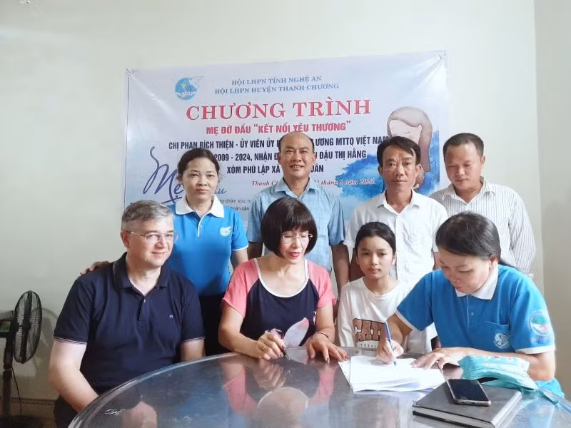 Mẹ đỡ đầu Phan Bích Thiện nhận đỡ đầu con nuôi Đậu Thị Hằng dưới sự chứng kiến của Hội phụ nữ và chính quyền địa phương.