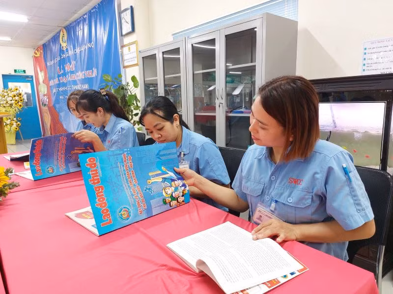 Công nhân công ty đọc sách báo sau giờ làm việc.