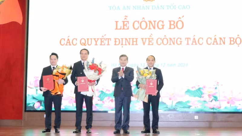 Chánh án Tòa án nhân dân tối cao Lê Minh Trí trao quyết định và tặng hoa chúc mừng các đồng chí được bổ nhiệm.