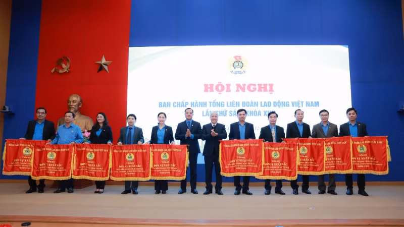 Các đồng chí Đỗ Văn Chiến và Nguyễn Đình Khang trao cờ thi đua của Tổng Liên đoàn Lao động Việt Nam tặng 10 tập thể có thành tích xuất sắc trong năm 2024.