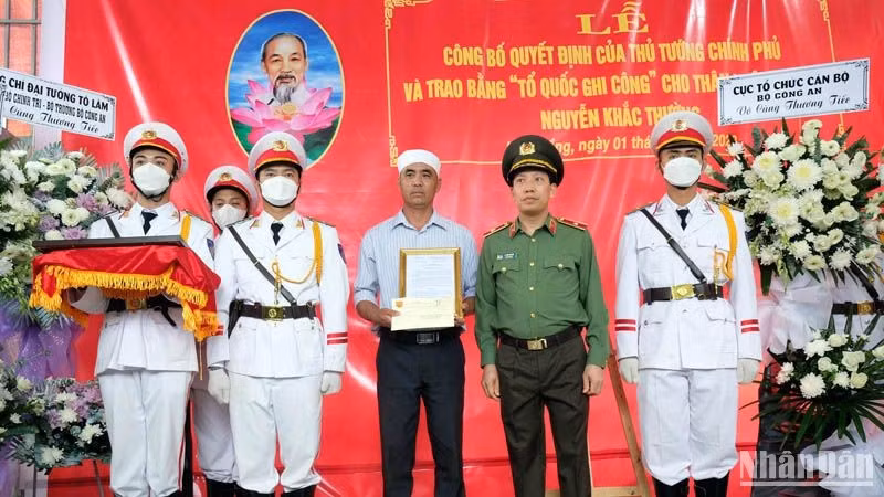 Thiếu tướng Lê Văn Tuyến trao quyết định của Bộ trưởng Công an cho thân nhân liệt sĩ - Trung tá Nguyễn Khắc Thường.