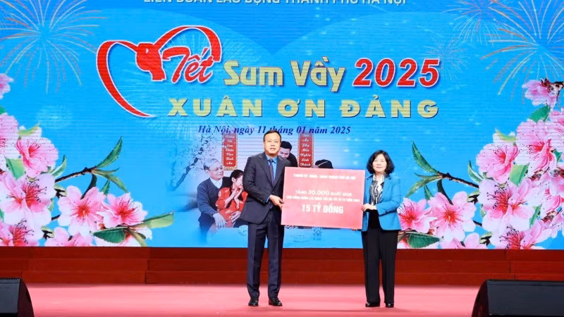 Bí thư Thành ủy Hà Nội Bùi Thị Minh Hoài trao bảng biểu trưng tặng 30 nghìn suất quà bằng tiền mặt trị giá 15 tỷ đồng. Đại diện công nhân, viên chức lao động Thủ đô, Chủ tịch Liên đoàn Lao động Thành phố Phạm Quang Thanh đón nhận.