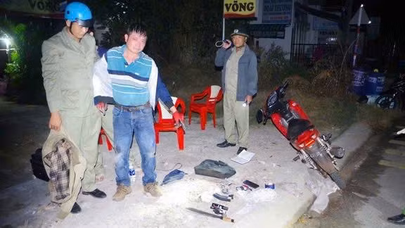 Lực lượng công an bắt đối tượng cùng hung khí. (Ảnh: Công an Bình Phước)