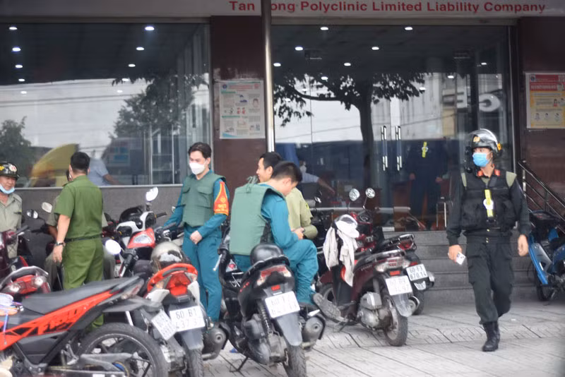 Lực lượng chức năng bao vây bên ngoài một phòng khám, chữa bệnh để phục vụ việc khám xét.