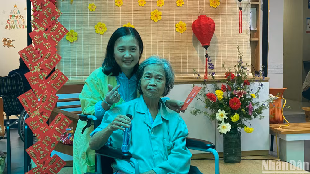 Bà Tạ Thị Dư (76 tuổi, thị trấn Phùng, Hà Nội) cùng con gái tại hội chợ xuân. 