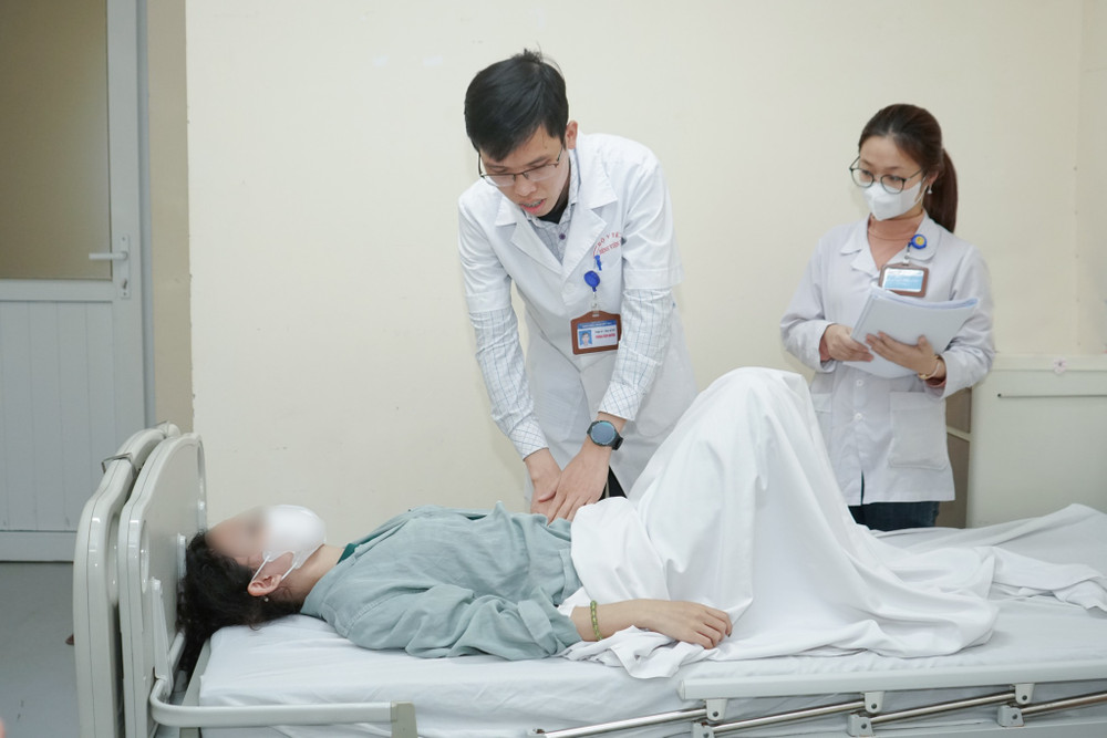 Bác sĩ khám lại cho người bệnh sau can thiệp.