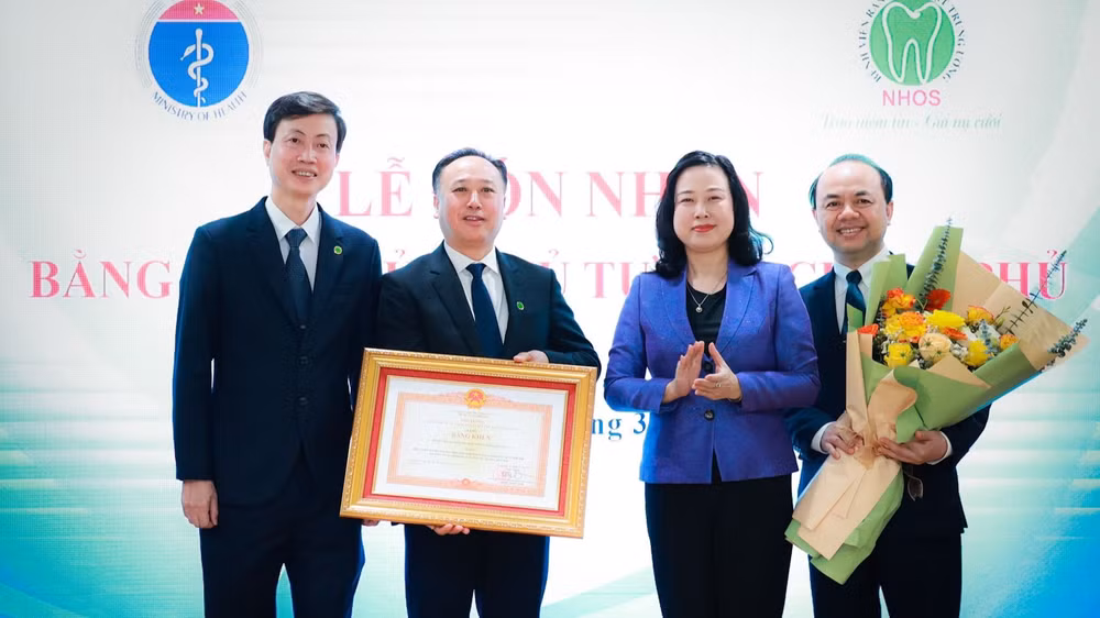 Bộ trưởng Y tế Đào Hồng Lan trao Bằng khen của Thủ tướng Chính phủ cho lãnh đạo Bệnh viện Răng Hàm Mặt Trung ương. (Ảnh: HẢI NGUYỄN)