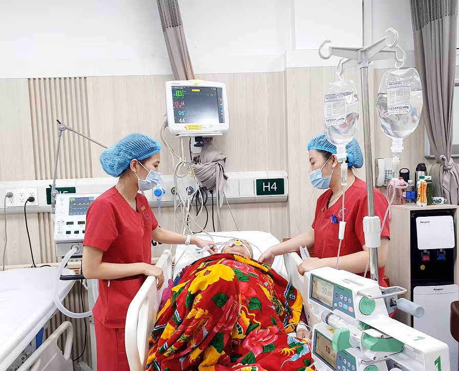 Điều dưỡng Đặng Thị Hạ (bên trái) chăm sóc bệnh nhân tại Trung tâm Cấp cứu A9 - Bệnh viện Bạch Mai.