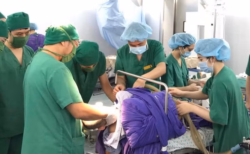 Các bác sĩ phẫu thuật cho người bệnh.