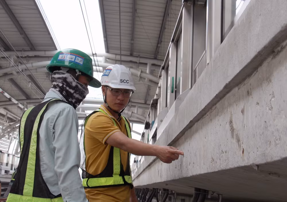 Các kỹ sư hướng dẫn công nhân kiểm tra chất lượng công trình.