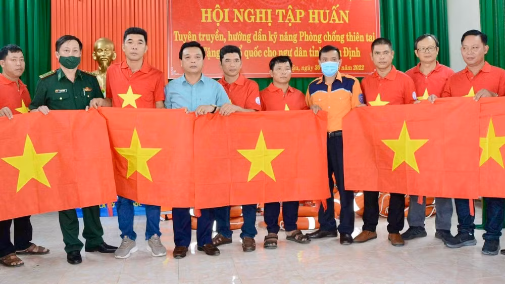 Đại diện báo Người Lao Động, Chi Cục Thủy sản tỉnh Nam Định, Bộ Chỉ huy Bộ đội Biên phòng tỉnh và Trung tâm phối hợp tìm kiếm cứu nạn hàng hải Việt Nam khu vực I trao cờ cho các ngư dân.