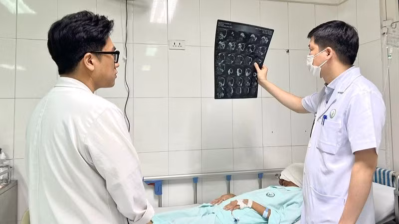 Bác sĩ thăm khám cho người bệnh sau phẫu thuật.