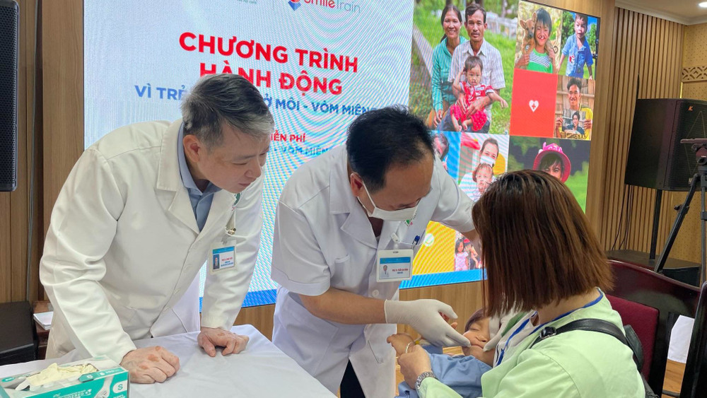Phó Giáo sư, Tiến sĩ Trần Cao Bính, Giám đốc Bệnh viện, Chủ tịch Hội Răng Hàm Mặt Việt Nam (giữa) thăm khám cho bệnh nhi. 