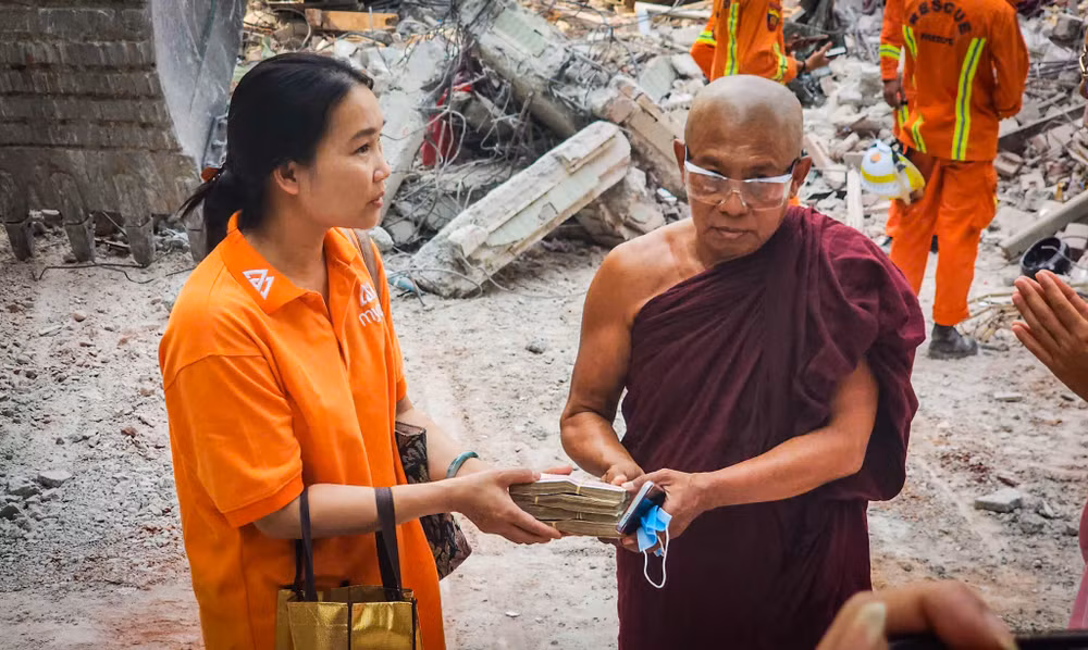 Chị Chu Thị Nguyệt trao quà, tiền hỗ trợ cho các nhà sư và người dân bị ảnh hưởng bởi động đất tại Sagaing - địa phương bị tàn phá nặng nề nhất. (Ảnh: THÀNH ĐẠT)
