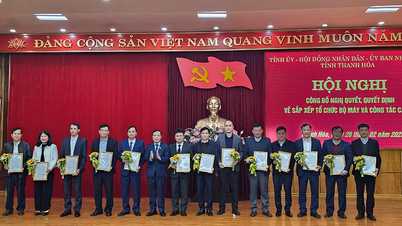 Phó Bí thư Thường trực Tỉnh ủy, Chủ tịch Hội đồng nhân dân tỉnh Thanh Hóa trao quyết định, tặng hoa cho các cán bộ được điều động, bổ nhiệm.
