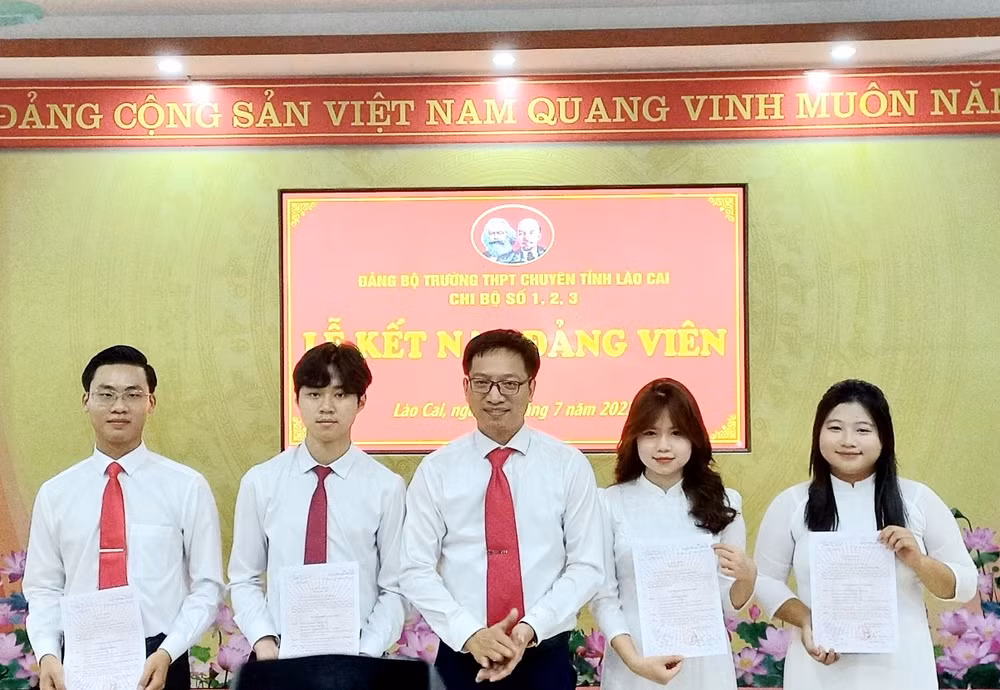Bí thư Đảng bộ Trường trung học phổ thông chuyên Lào Cai Ngô Thanh Xuân chúc mừng các học sinh được kết nạp vào Đảng, chiều 12/7. (Ảnh: TL)