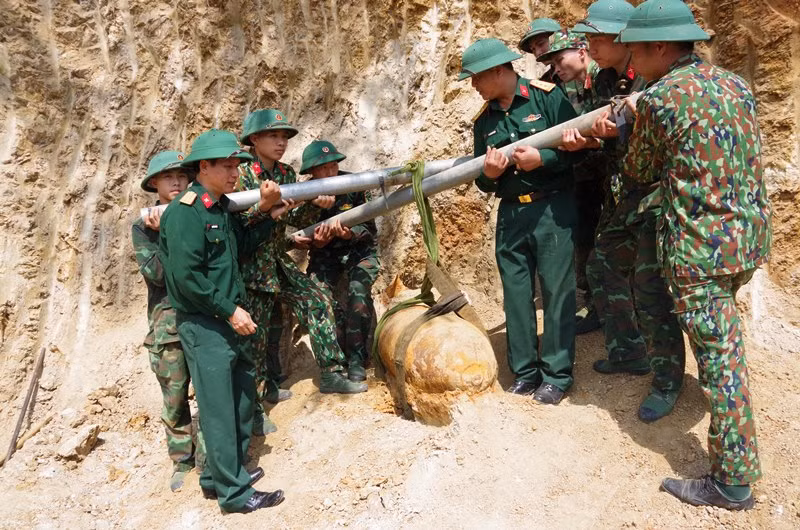 Di dời quả bom lên khỏi mặt đất. (Ảnh: HỒ TRÚC)
