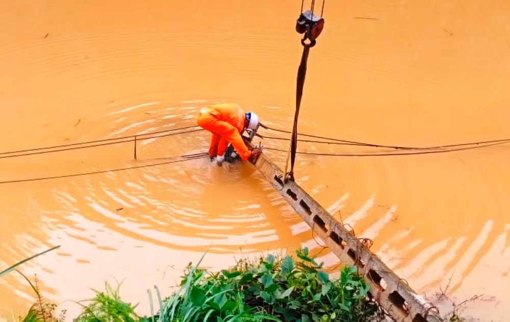 Công nhân Điện lực Bảo Thắng khắc phục sự cố do mưa lũ. (Ảnh: QUỐC HỒNG)