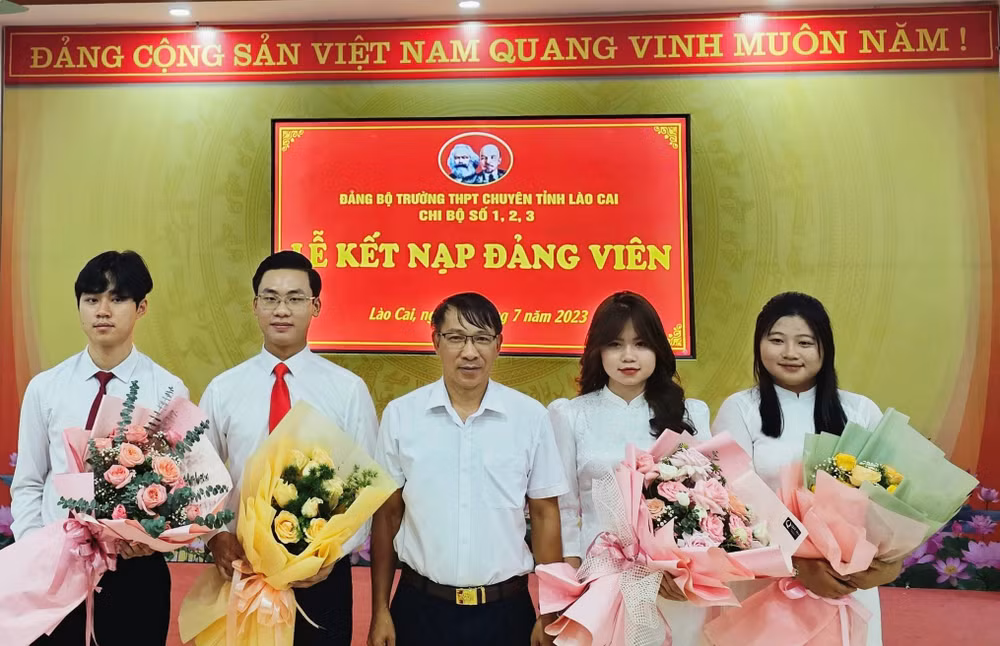 Phó Trưởng Ban Tổ chức Tỉnh ủy Lào Cai Ngô Hữu Quý tặng hoa chúc mừng các đảng viên mới được kết nạp. (Ảnh: TL)