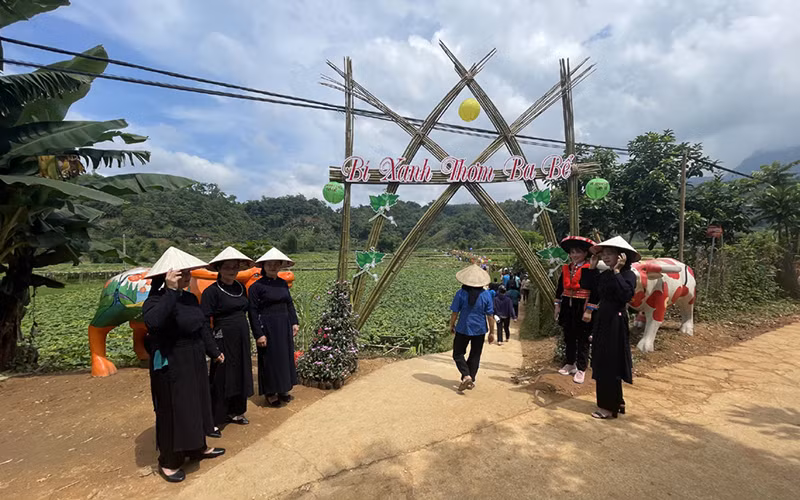 Chương trình du lịch gắn với trải nghiệm bí xanh thơm là sản phẩm du lịch độc đáo. (Trong ảnh: Người dân đón du khách đến thăm vườn bí trong chương trình tổ chức năm 2022). 