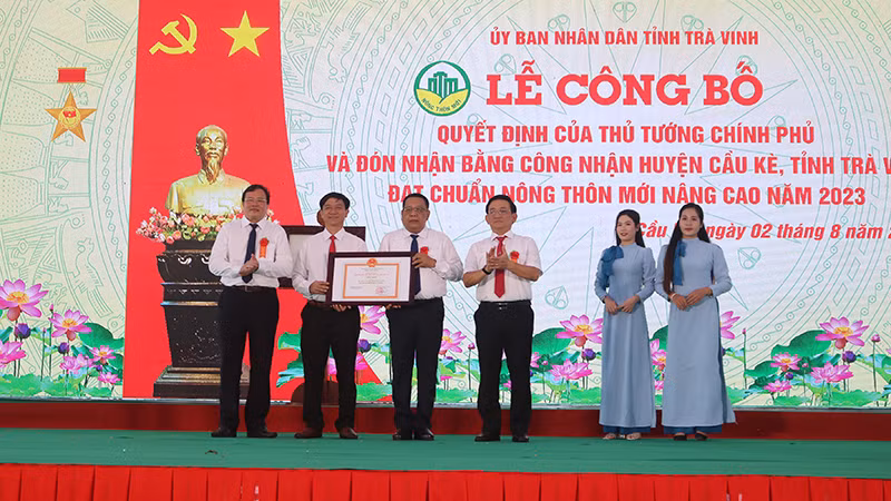 Đại diện lãnh đạo huyện Cầu Kè đón nhận Bằng công nhận huyện đạt chuẩn nông thôn mới nâng cao.