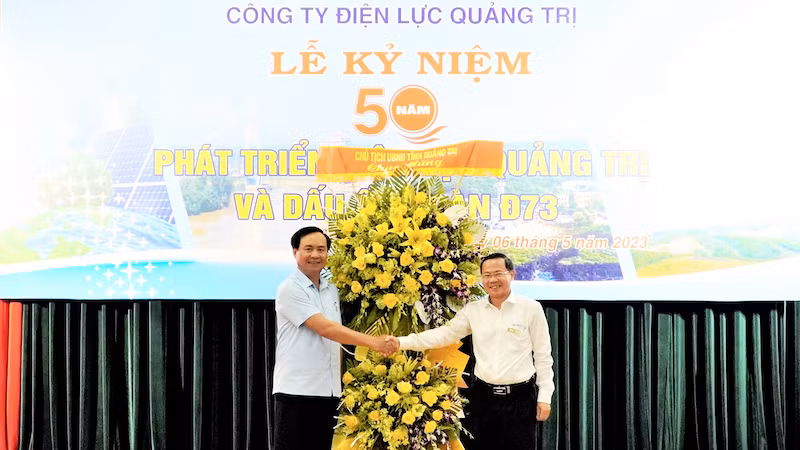 Phó Bí thư Tỉnh ủy, Chủ tịch Ủy ban nhân dân tỉnh Quảng Trị Võ Văn Hưng (bên trái) tặng hoa chúc mừng Công ty Điện lực Quảng Trị. (Ảnh: LÂM QUANG HUY)