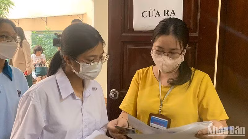 Giám thị gọi thí sinh vào phòng thi theo số báo danh tại điểm thi Trường đại học Sư phạm Hà Nội. (Ảnh: THÚY QUỲNH)