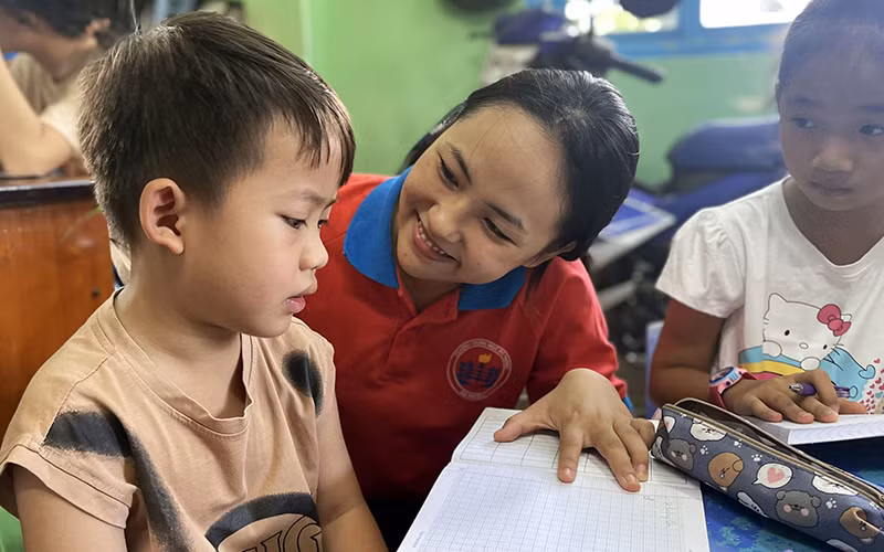 Chiến sĩ tình nguyện “Hoa phượng đỏ” của Thành phố Hồ Chí Minh kèm cặp, hỗ trợ thiếu nhi học tập, rèn luyện ngày hè. (Ảnh Thành đoàn Thành phố Hồ Chí Minh)