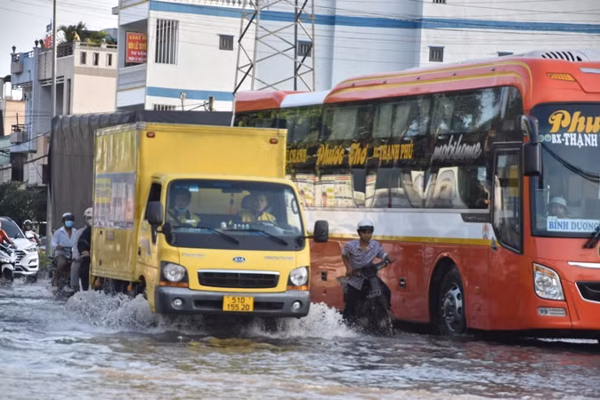 Người dân và phương tiện di chuyển khó khăn qua khu vực Vòng xoay Trung Lương, thành phố Mỹ Tho (Tiền Giang) vào chiều 11/3.