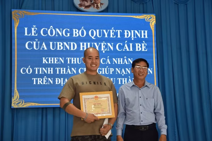 Lãnh đạo huyện Cái Bè trao giấy khen cho anh Phan Quốc Huy.