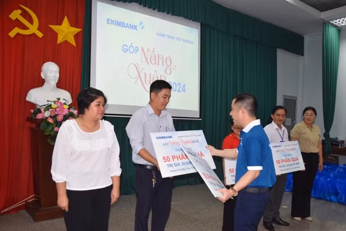 Trao bảng tượng trưng cho các đơn vị có người dân nghèo đến nhận quà.