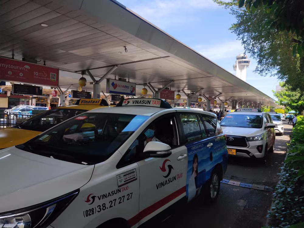 Các hãng taxi đón khách tại làn C sân bay Tân Sơn Nhất. (Ảnh: THẾ ANH)
