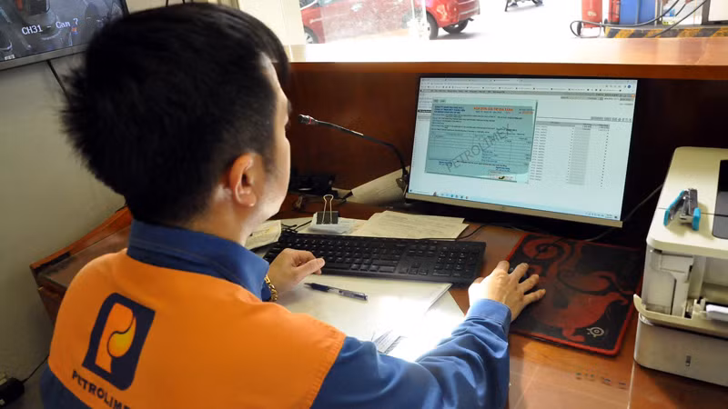 Nhân viên xuất hóa đơn ngay cho khách hàng sau khi mua xăng tại Petrolimex.