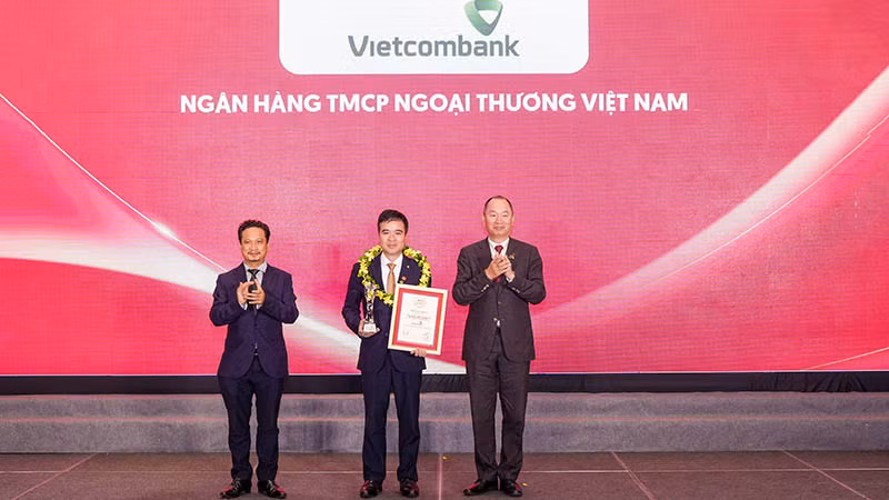 Đại diện Vietcombank (đứng giữa) nhận danh hiệu “Ngân hàng uy tín nhất Việt Nam năm 2023” từ Ban Tổ chức.