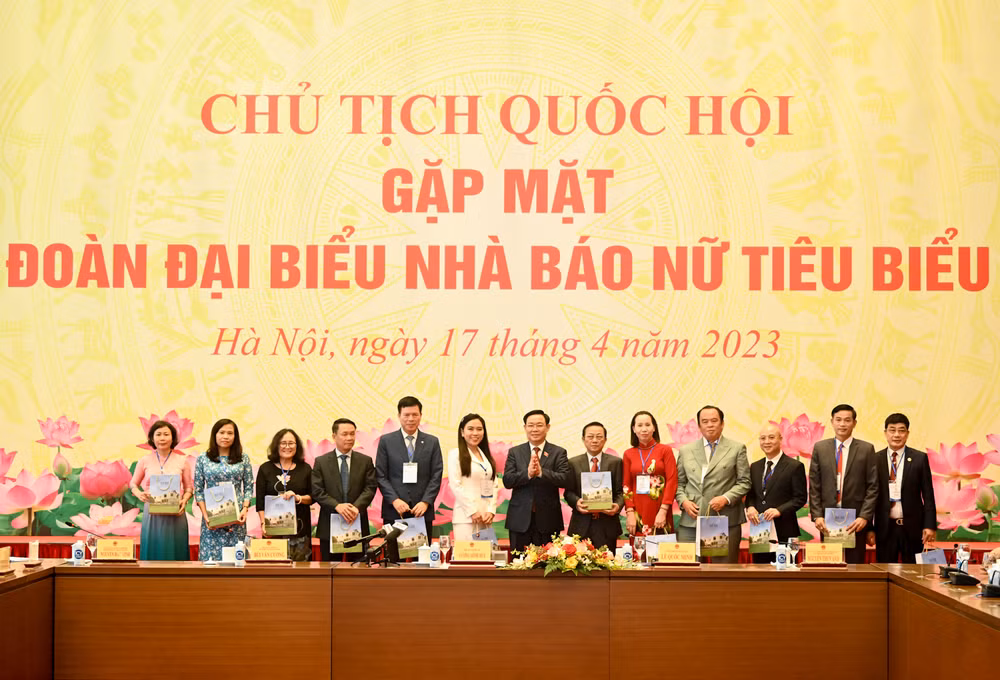 Chủ tịch Quốc hội Vương Đình Huệ trao quà lưu niệm cho các nhà báo nữ tại cuộc gặp mặt.