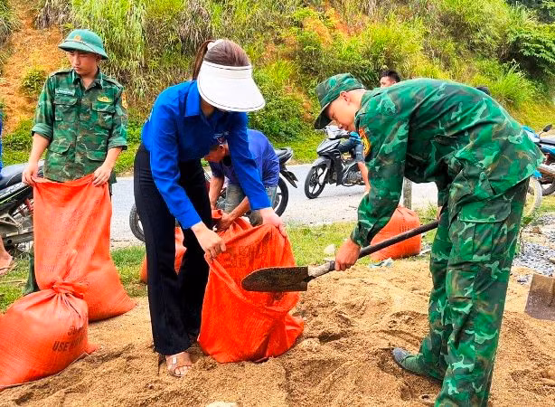 Thanh niên tình nguyện cùng Bộ đội Biên phòng xúc, vận chuyển vật liệu phục vụ chỉnh trang trường học.