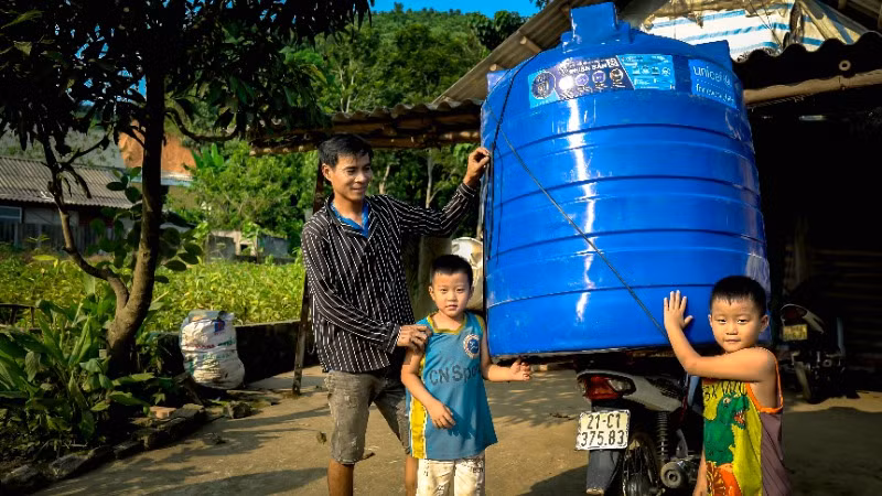 Người dân Yên Bái bị ảnh hưởng bởi bão lũ nhận thùng nước hỗ trợ từ UNICEF. (Ảnh: UNICEF Việt Nam) 