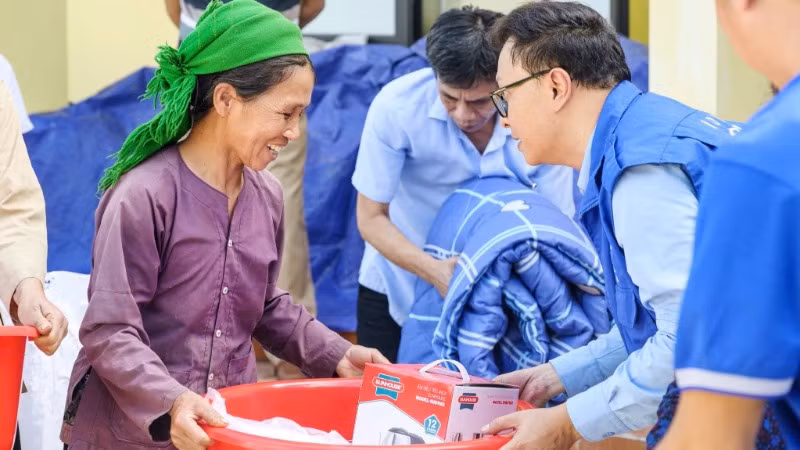 Cán bộ IOM trao hỗ trợ cho người dân bị ảnh hưởng bởi bão lũ. (Ảnh: IOM Việt Nam)