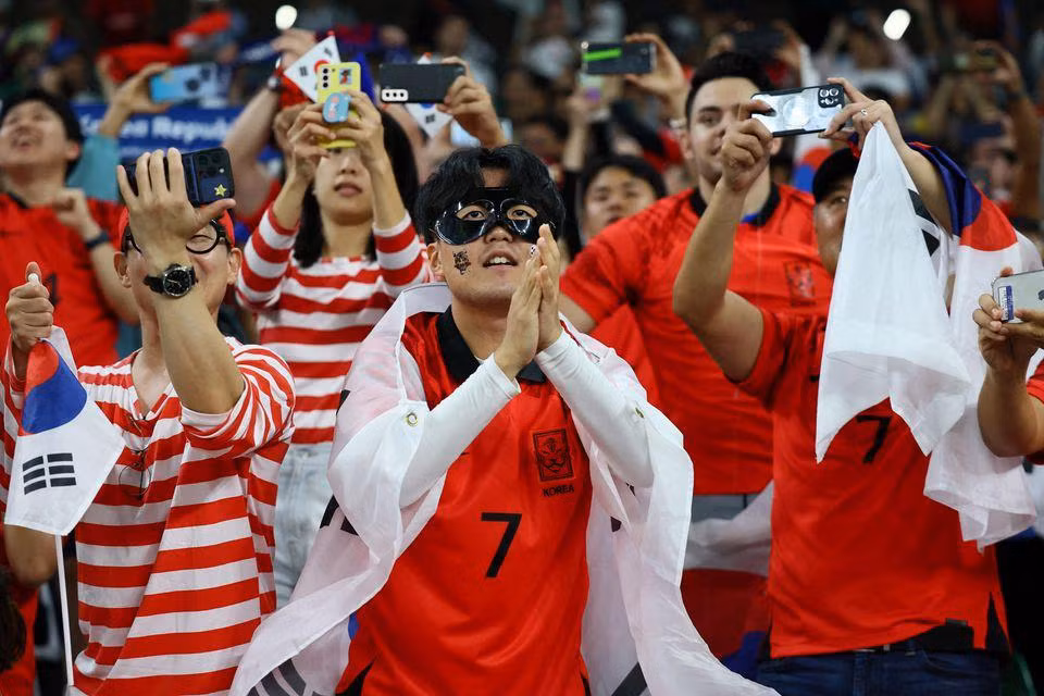 Người hâm mộ Hàn Quốc ăn mừng trên khán đài sau khi đội tuyển nước này đoạt vé vào vòng loại trực tiếp. (Ảnh: Reuters)