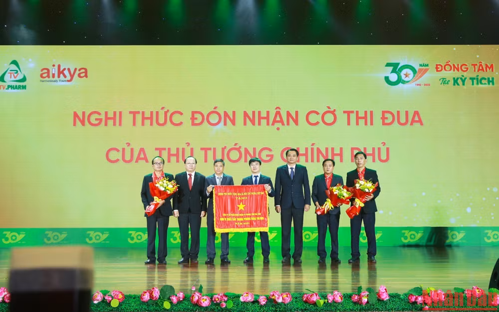 Phó Chủ tịch Ủy ban nhân dân tỉnh Trà Vinh Nguyễn Quỳnh Thiện, (thứ ba bên phải), thừa ủy quyền của Thủ tướng Chính phủ, trao Cờ Thi đua xuất sắc năm 2021 cho tập thể Công ty cổ phần Dược phẩm Trà Vinh.